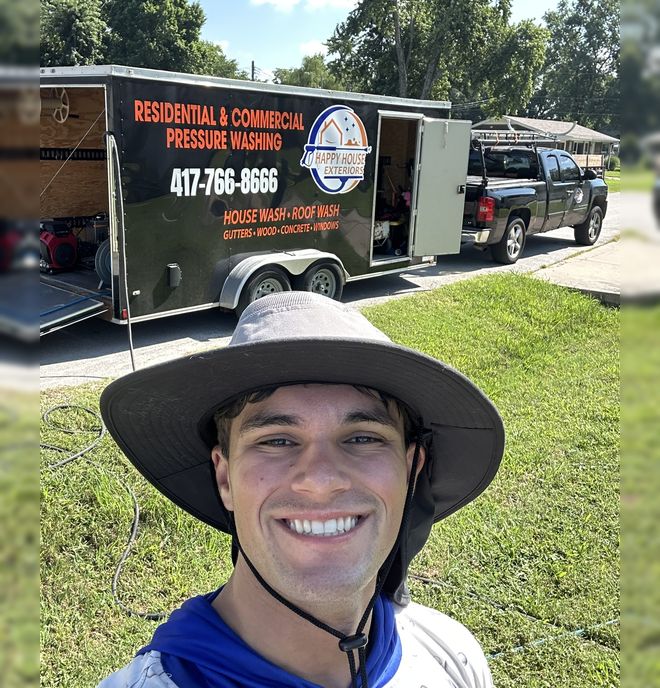 Alex Southard, owner of Happy House Exteriors, in front of the company truck and trailer